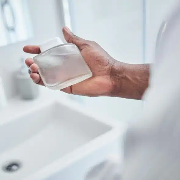 A man holding an empty perfume bottle