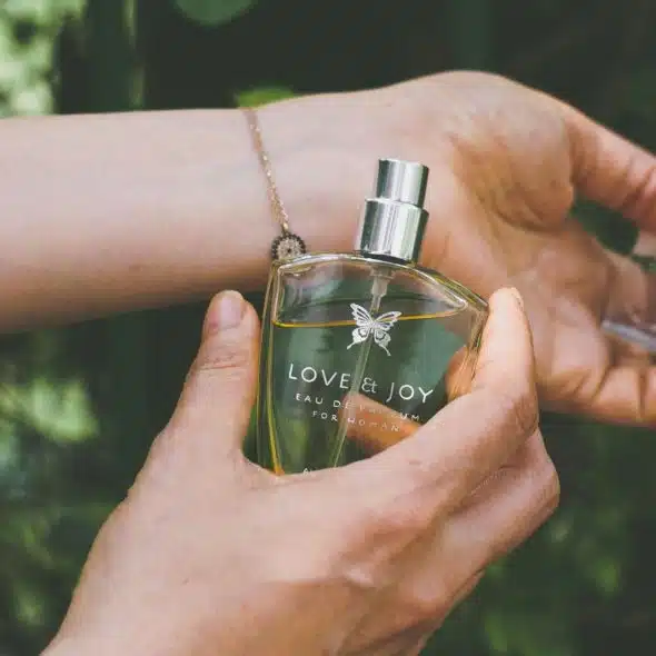 A person spraying perfume.