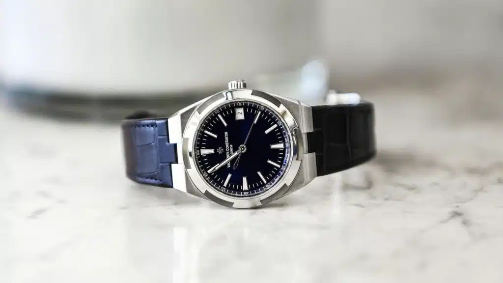 A stainless steel Vacheron Constantin watch with a blue dial and black leather strap.