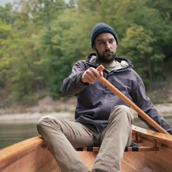Man paddling canoe in the lake forest.