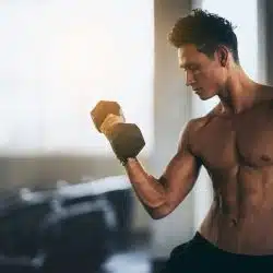 A man lifting a dumbbell to flex muscle