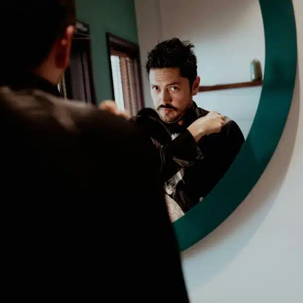 A man looking at the mirror.