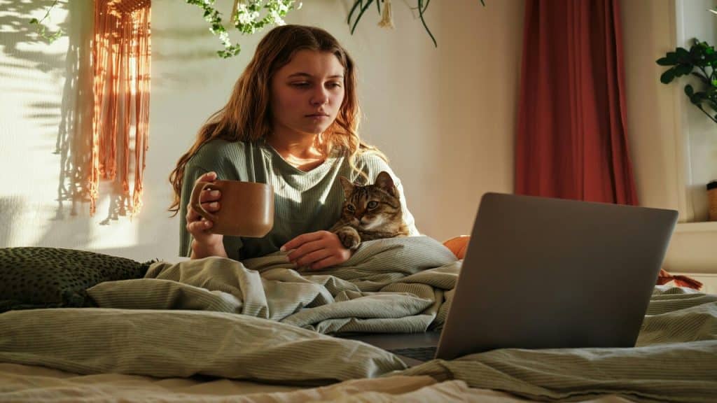 A woman looking sad in front of a laptop.