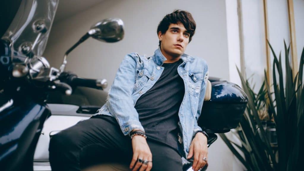 Rugged man in distressed denim jacket exuding masculine confidence