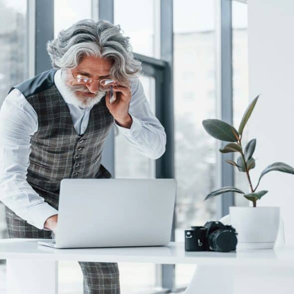 A handsome older man working in an office.