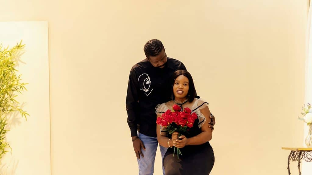 A man standing next to a woman holding a bouquet of flowers.