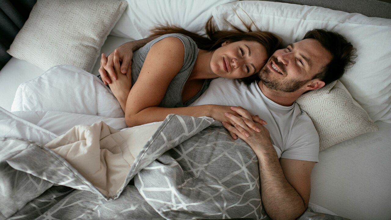 A couple cuddling in bed