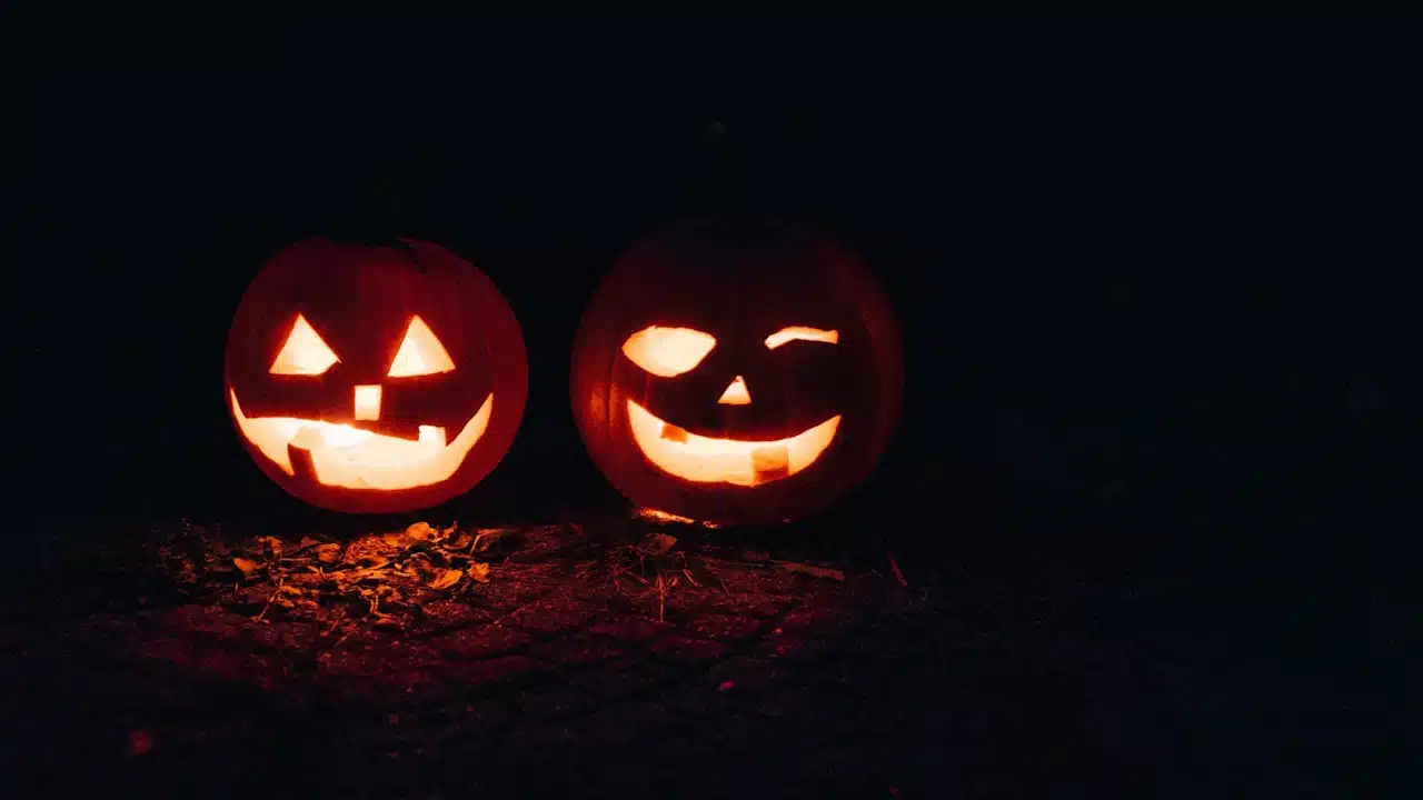 Two Pumpkin jack-o-lanterns glowing in the dark.