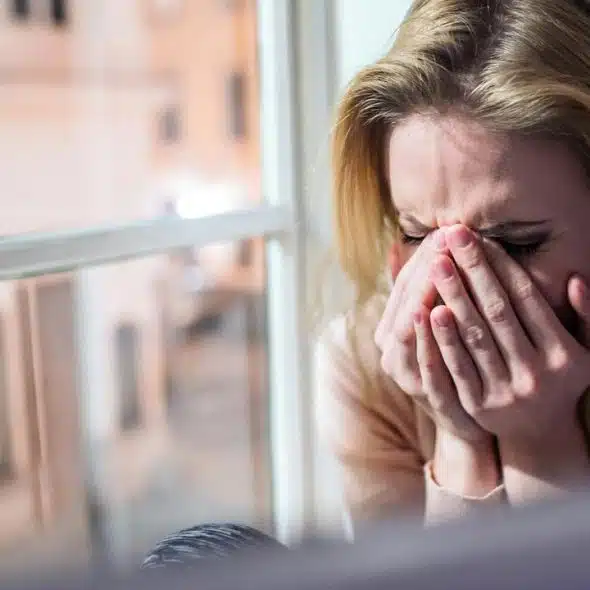 A woman covering her face while crying