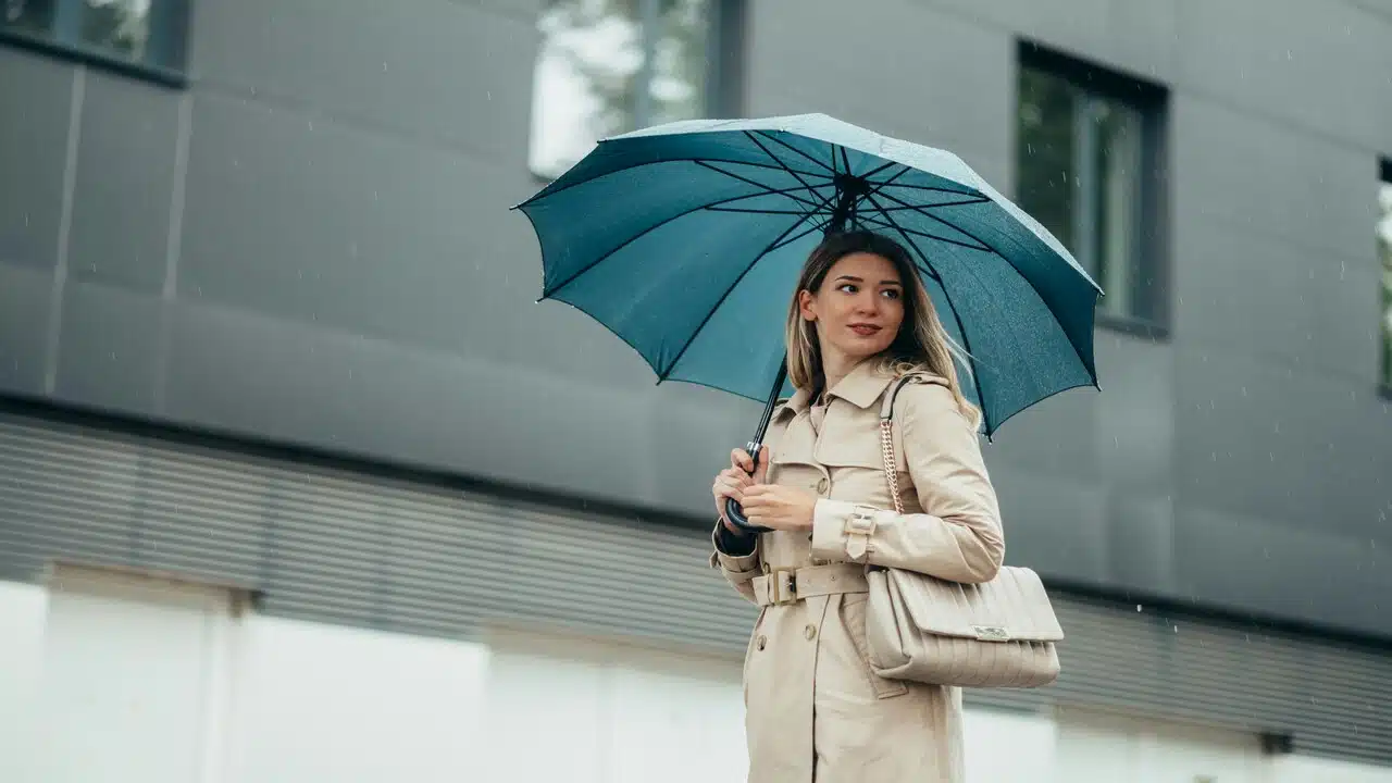 A woman carryingy a blue umbrella.