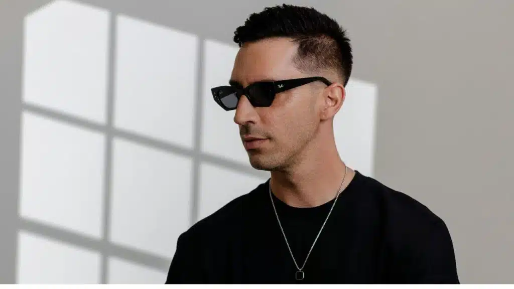 Man in casual henley and subtle chain standing confidently