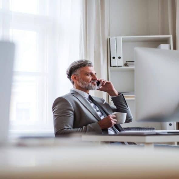 A businessman on the phone and having coffee