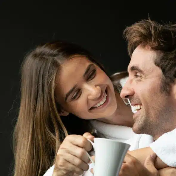 A smiling couple in white robes