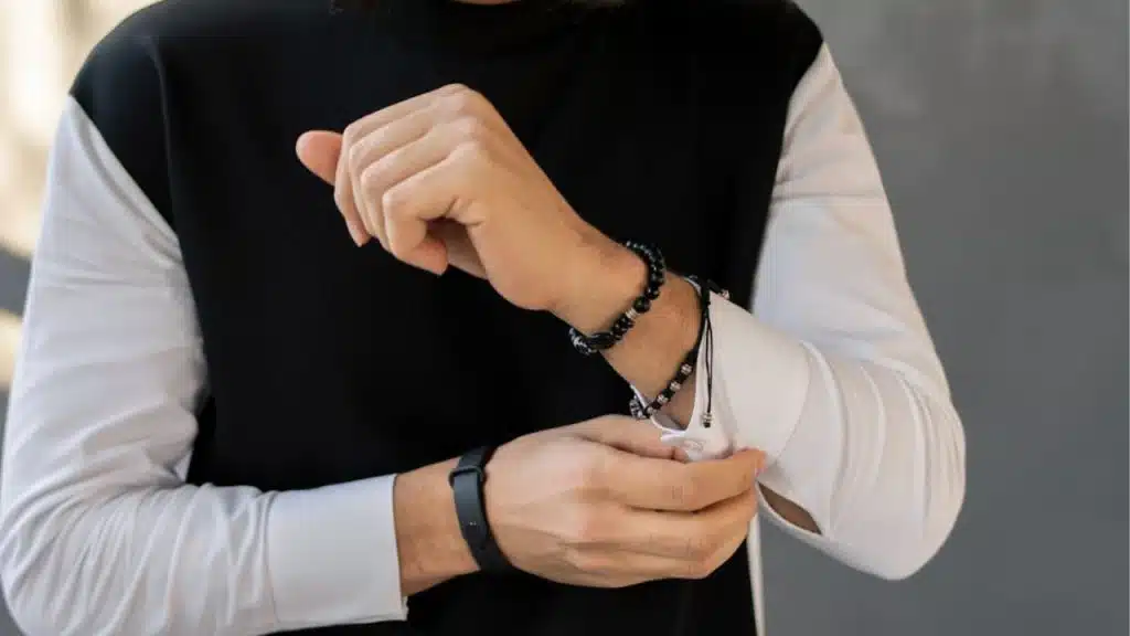 Man’s wrist with wooden and black beaded bracelets