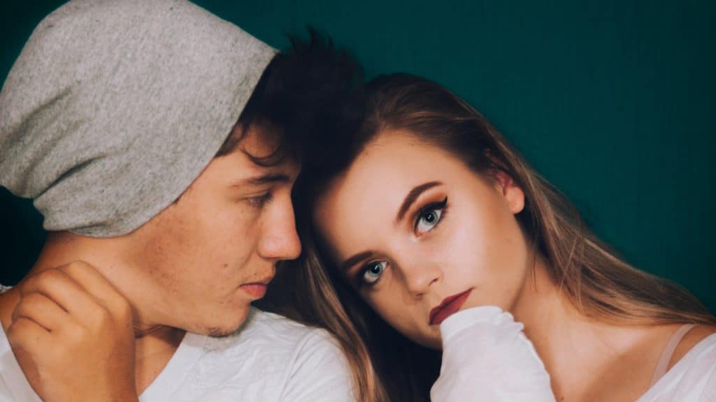 A man standing beside a woman while staring.