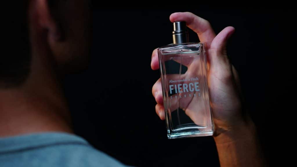 The man is using a cologne.