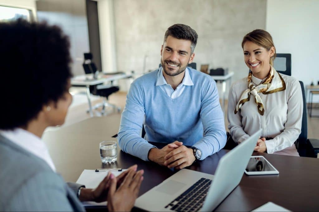 A man and woman talking with their colleague