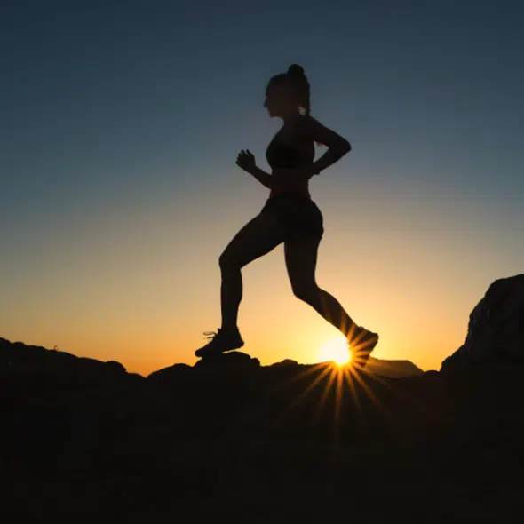 Silhouette of a female runner at sunset