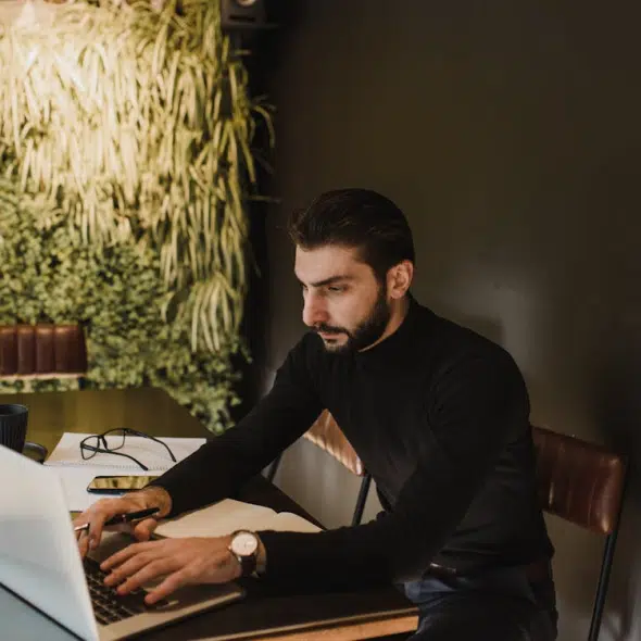A Man Typing on a Laptop