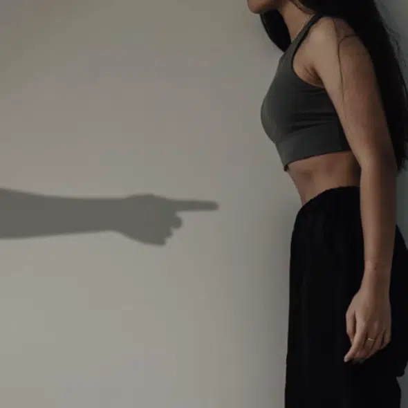 A man’s hand pointing at a woman’s stomach