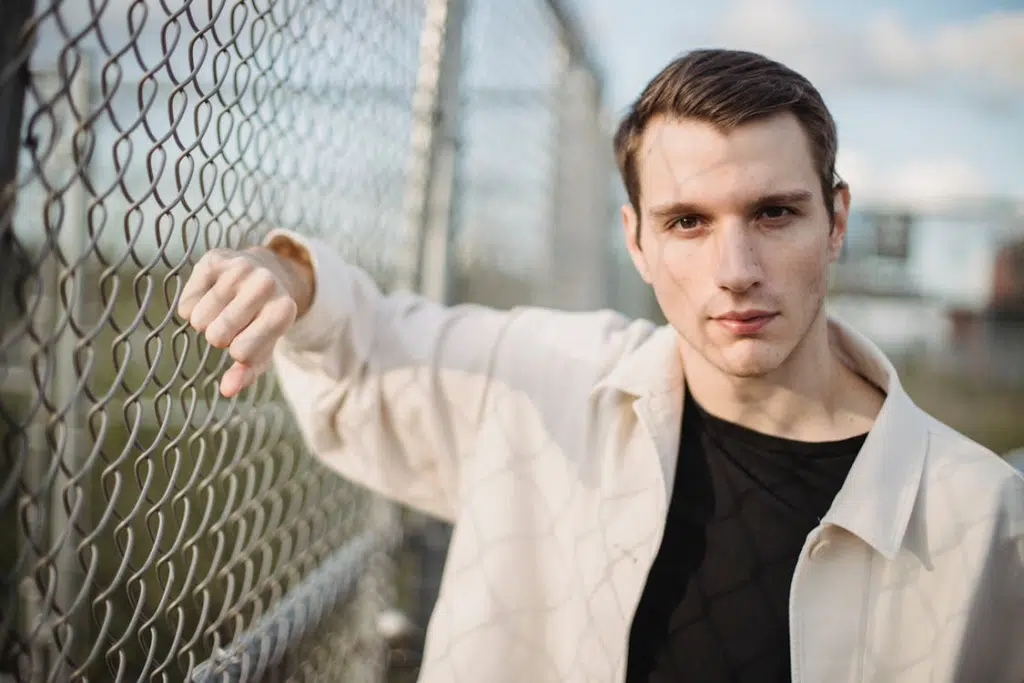 Man leaning on grid fence