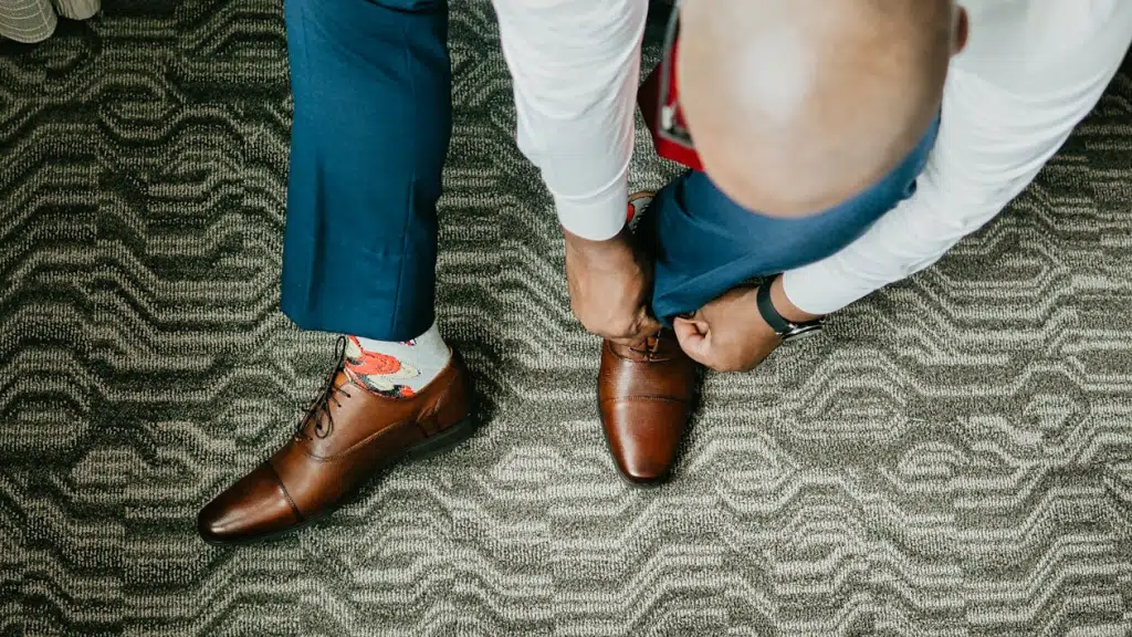Man tying shoes in room